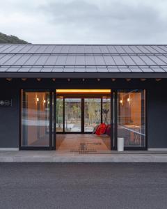 ein Gebäude mit Glastüren und einem Metalldach in der Unterkunft tango resort ragura kitsu bettei in Kyōtango