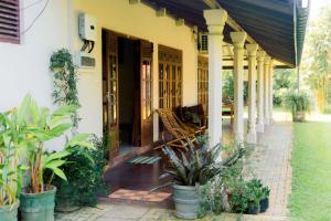 a porch of a house with a bench and plants at Abalone Stay in Bentota