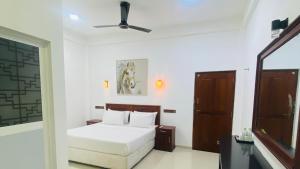 une chambre avec un lit et un ventilateur de plafond dans l'établissement HMC Lesiure House Dondra, à Dondra North 19 autres photos