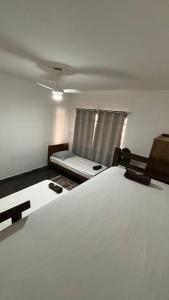 a bedroom with a white bed and a window at Casa com 3 quartos in Itu