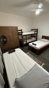 a room with two beds and a ceiling fan at Casa com 3 quartos in Itu +4 photos