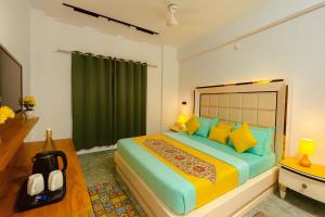een slaapkamer met een groot bed met gele en blauwe kussens bij Hotel Aura Residency By Sitara Group, Haridwar in Haridwār
