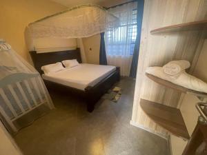 a small bedroom with a bed with a canopy at A Oasis Taveta in Taveta
