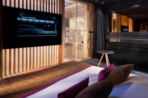 a bedroom with a bed with a flat screen tv at Le Colombier in Obernai