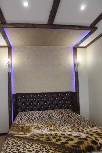 マイコープにあるApartments on Chkalovaの紫色のライトが備わるドミトリールームのベッド1台分です。