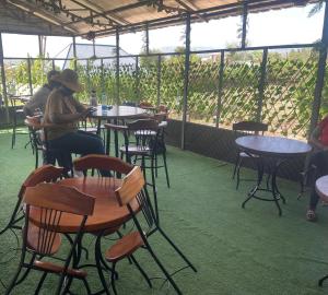 a group of people sitting at tables in a restaurant at A Oasis Taveta in Taveta