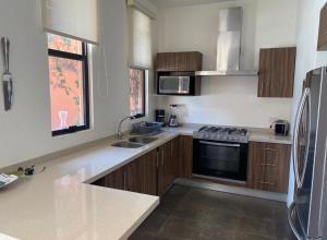 een keuken met houten kasten en een roestvrijstalen koelkast bij Marbe in San Miguel de Allende