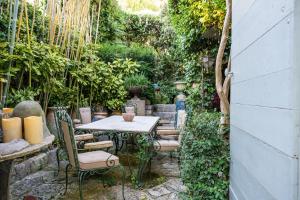 un patio con tavolo e sedie in un giardino di Rock House Pool & Authentic 17th-Century Home a Goult Altre 29 foto