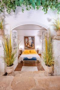 una camera con un letto e due piante in vaso di Rock House Pool & Authentic 17th-Century Home a Goult