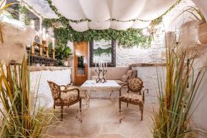 una stanza con tavolo, sedie e piante di Rock House Pool & Authentic 17th-Century Home a Goult