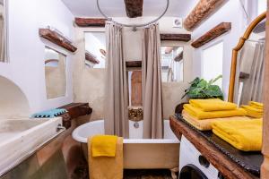 bagno con vasca, doccia e lavandino di Rock House Pool & Authentic 17th-Century Home a Goult