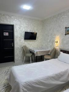 a bedroom with a bed and a table and a tv at Imran&Bek in Samarkand