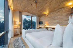 a bedroom with a white bed and a large window at Fusion Suites Saigon in Ho Chi Minh City +61 photos