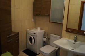 łazienka z toaletą, umywalką i pralką w obiekcie Apartament Maria w mieście Międzyzdroje +37 zdjęć