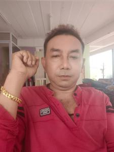 ein Mann in einem roten Hemd mit der Hand zur Faust in der Unterkunft haadrin village DC in Haad Rin