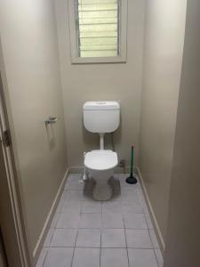 a bathroom with a toilet and a window in it at GOROKA Home Stay in Goroka