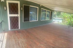 an empty room with a wooden floor and windows at GOROKA Home Stay in Goroka