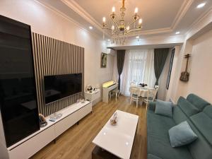 a living room with a blue couch and a large television at У Эльмана in Sumqayyt