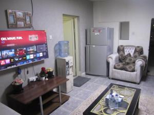 un salon avec une télévision et une chaise dans l'établissement العين الهيلي مصباح ب1, à Al-Aïn