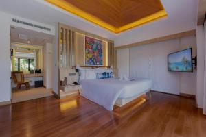 a bedroom with a large white bed and a desk at Centara Villas Phi Phi Island in Phi Phi Don
