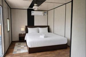 a bedroom with a large white bed in it at Mud Meadows - Peace and Tranquility 3br Farm in Faridabad