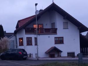 een wit huis met een auto ervoor geparkeerd bij Ferienwohnung Matheaperle in Nidda
