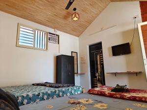 a room with two beds and a tv in it at His Grace BEACH AVENUE, Malpe Beach in Udupi