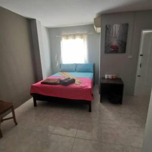 ein Schlafzimmer mit einem Bett mit einer roten Decke und einem Fenster in der Unterkunft haadrin village DC in Haad Rin