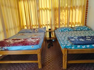 two beds sitting next to each other in a room at His Grace BEACH AVENUE, Malpe Beach in Udupi