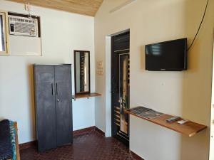a room with a tv on the wall and a cabinet at His Grace BEACH AVENUE, Malpe Beach in Udupi