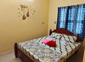 a bedroom with a bed with two pillows on it at Nilan Aarudhra Homestay in Chidambaram