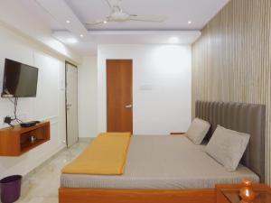 a bedroom with a bed and a flat screen tv at Hotel Nest In in Mumbai
