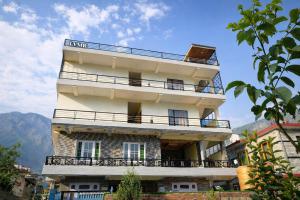 a tall building with balconies on top of it at LVMR RIDERS REST Homestay in Kulu