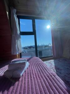 a bedroom with a bed with two towels and a window at Redi house in Batumi