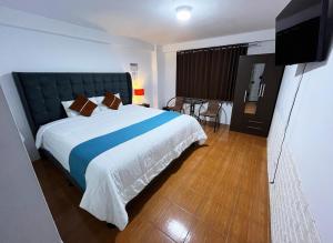 a bedroom with a large bed and a television at Hostal Cusco de mis Sueños in Cusco