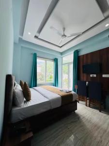 a bedroom with a bed with blue walls and a window at D S valley in Rishīkesh