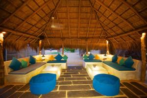 an outdoor seating area with blue and yellow pillows at Dolphin Beach Resort in Kalpitiya