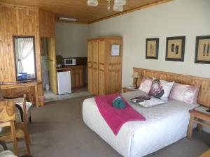 a bedroom with a large bed and a kitchen at Ladybrand Guest House in Ladybrand