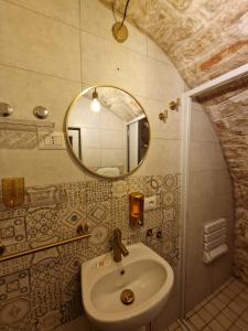 een badkamer met een wastafel en een spiegel bij Soffio di Pietra in Castellana Grotte