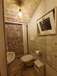 een kleine badkamer met toilet en wastafel bij Soffio di Pietra in Castellana Grotte