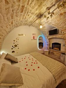 een slaapkamer met een bed met rode rozenblaadjes erop bij Soffio di Pietra in Castellana Grotte