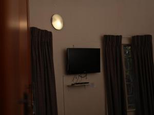 a flat screen tv on the wall next to a window at Awelani Eco Tourism Lodge in Masisi