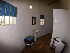 a white bathroom with a sink and a sink at Awelani Eco Tourism Lodge in Masisi +44 photos