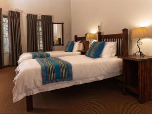 a hotel room with two beds with blue pillows at Awelani Eco Tourism Lodge in Masisi