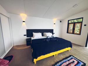 a bedroom with a large bed with a blue blanket at White Monkey Dias Rest in Haputale