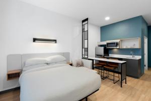 a hotel room with a bed and a kitchen at StudioRes by Marriott Newnan in Newnan