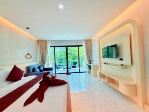 a bedroom with a large bed and a tv on a wall at Pure Sand Lanta Resort in Ko Lanta