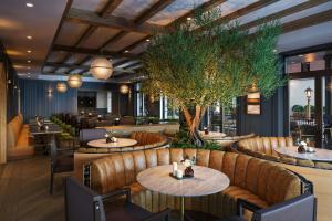 a restaurant with tables and a tree in the middle at The Union Hotel, Flemington, a Tribute Portfolio Hotel in Flemington