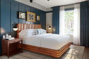 a bedroom with a large bed with blue walls at The Union Hotel, Flemington, a Tribute Portfolio Hotel in Flemington