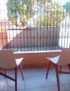 deux chaises assises devant une fenêtre dans l'établissement Nova Casa Studio Mega - Qto1 c Ar - 3 Vagas Garagem - Esp Térreo Priv - WiFi 300 Megas - Home Office a 200 mts Praia da Pompéia, à Santos